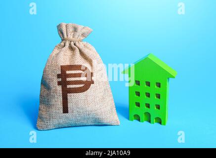 Philippine peso money bag and green Investments in sustainable housing. Investment in green technologies. Reduced emissions, improved energy efficienc Stock Photo