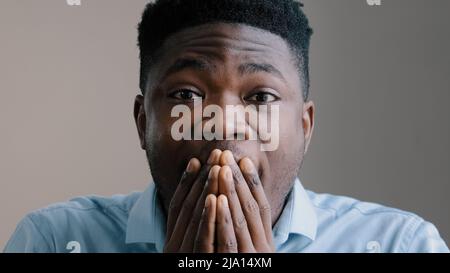 Shocked happy african american young boyfriend business man surprised look at camera rejoice good news amazed guy joyful male winner show wow reaction Stock Photo