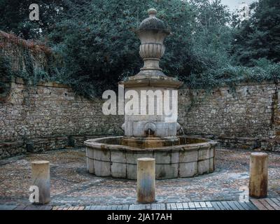 Old stone fountain in a public square in Avilés, Asturias, Spain Stock Photo