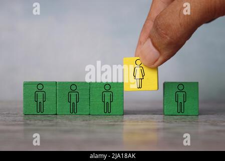 Hand put female into the male team. Create gender balance in the company, gender diversity concept. Stock Photo
