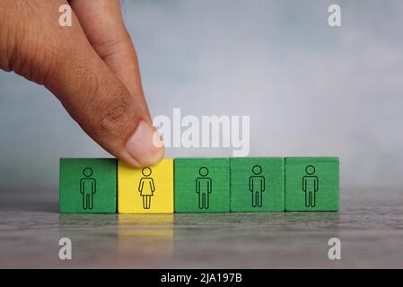 Hand put female into the male team. Create gender balance in the company, gender diversity concept. Stock Photo