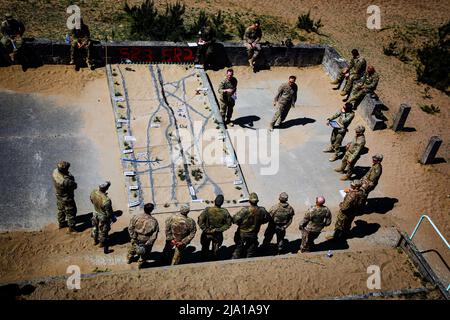 May 16, 2022 - Oberlausitz, Germany - U.S. Army Lt. Col. Andrew Rhodes, battalion commander, and U.S. Army Capt. David Reagan, Alpha company commander both from the 1st Battalion, 8th Infantry Regiment, 3rd Armored Brigade Combat Team, 4th Infantry Division, conduct a debrief with German soldiers assigned to the 212th Panzergrenadier Battalion, 21st Panzer Brigade, 1st Panzer Division, after a situational training exercise at Oberlausitz Training Area, Germany, May 16, 2022. Defender Europe 22 is a series of U.S. Army Europe and Africa multinational training exercises taking place in Eastern E Stock Photo