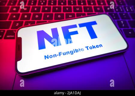 In this photo illustration, a Non-Fungible Token (NFT) logo is displayed on the smartphone screen. Stock Photo