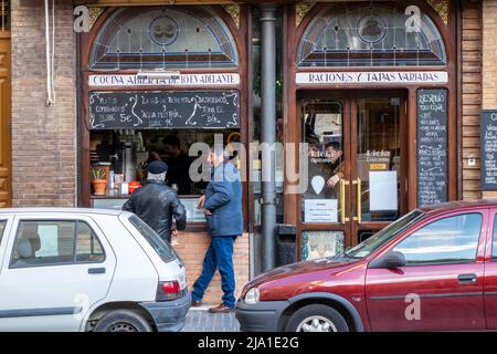 Two Men Outside The Cafeteria Rioja Pasaje In Jesús del Gran Poder, Seville Spain Stand At The Window Counter On The Pavement Stock Photo