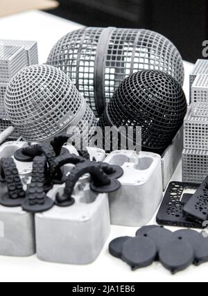 Many different objects printed on 3D printer from powder polyamide. Models printed on industrial 3D printer. Modern new prototyping technology. Additive automation manufacturing 3D printing technology Stock Photo