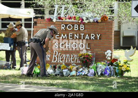 Uvalde, Texas, USA. 25th May, 2022. A Texas Department of Public Safety officer places memorials outside Robb Elementary school in south Uvalde where a lone gunman killed 19 schoolchildren and 2 teachers. (Credit Image: © Bob Daemmrich/ZUMA Press Wire) Stock Photo