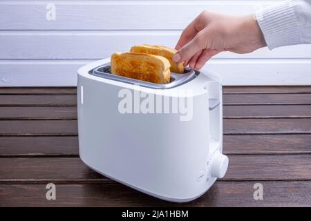 Slices of great toast coming out of the toaster. Healthy breakfast food and heating technology concept. Stock Photo