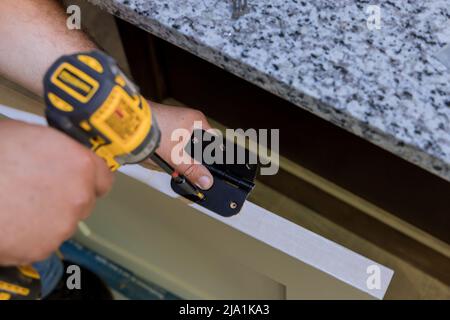 Master installs the stainless door hinge on for interior door Stock Photo