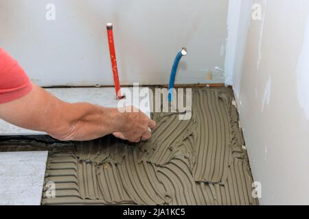 Working tiles lay a tile on the floor Stock Photo