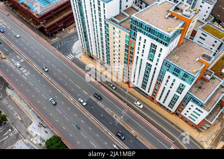 Aerial view of a busy city street with modern office buildings, lush ...