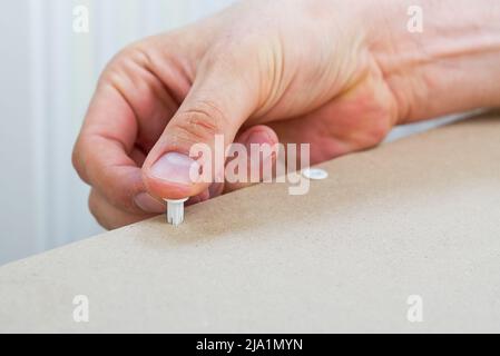 Professional Furniture Assembly Worker Assembles Shelf. Furniture assembly process. DIY Assembling Stock Photo