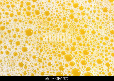 Closeup of orange juice foam, top view. Splash of fresh sweet orange, mango, fruit juice. Stock Photo