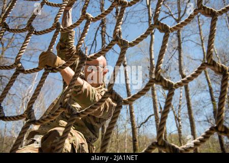 Camp Ripley, Minnesota, USA. 14th May, 2022. Sgt. Joshua Kleinhans of Kiel, Wisconsin, a Fire Control Specialist with the Wisconsin National Guard's B Battery, 1st Battalion, 121st Field Artillery Regiment descends the rope net of the obstacle course during the Region IV Best Warrior Competition on May 14, 2022. He is one of twelve National Guard Soldiers competing in the Region IV Best Warrior Competition May 11-15, 2022, at Camp Ripley, Minnesota. The annual competition tests the military skills, physical strength and endurance of the top Soldiers and noncommissioned officers from the Minn Stock Photo