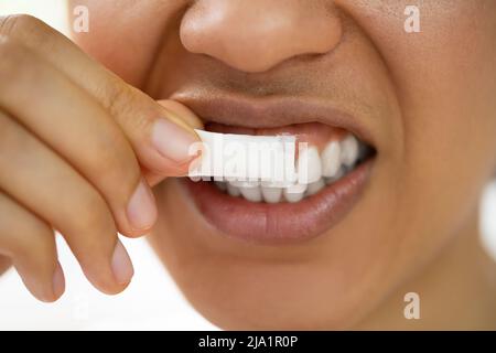 Woman Using Nicotine Gum To Quit Smoking. Nicotine Replacement Therapy Stock Photo