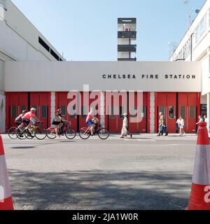 London, Greater London, England, May 14 2022: Cyclists and pedestrians pass by Chelsea Fire Station on The Kings Road. Stock Photo