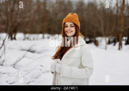 woman in winter clothes in a hat fun winter landscape There is a