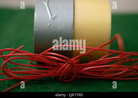 Different colored duct tapes and a red plastic string Stock Photo