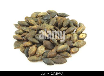 Pile of roasted unshelled pumpkin seeds isolated on white background Stock Photo