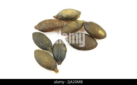 Few unshelled and roasted pumpkin seeds isolated on white background Stock Photo