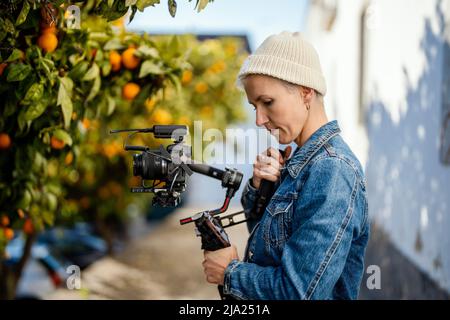 Camera operator with movie setup including a gimbal, video transmitter and wireless microphone Stock Photo