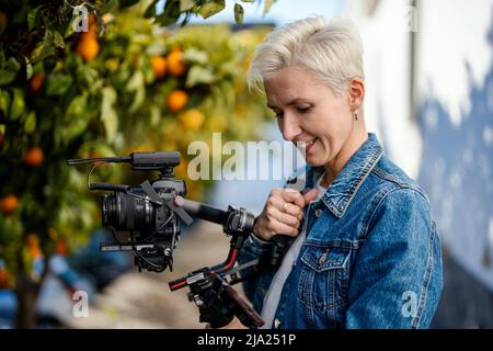 Camera operator with movie setup including a gimbal, video transmitter and wireless microphone Stock Photo