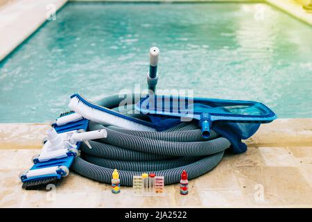 Pool cleaning and maintenance tools, image of pool cleaning and maintenance kit, vacuum cleaner, ph test, leaf picker and pool sweeper Stock Photo