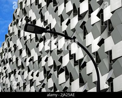 black curved streetlight against monochrome modernist geometric angular facade of city-centre building in Sheffield, Yorkshire, England, UK Stock Photo