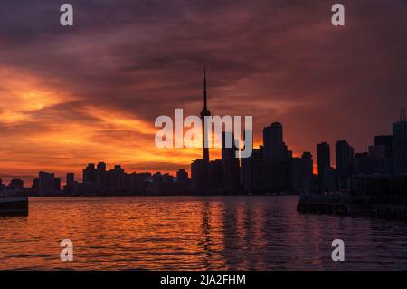 Summer sunset view from Toronto Islands across the Inner Harbour of the Lake Ontario on Downtown Toronto skyline with skyscrapers under a magnificent Stock Photo