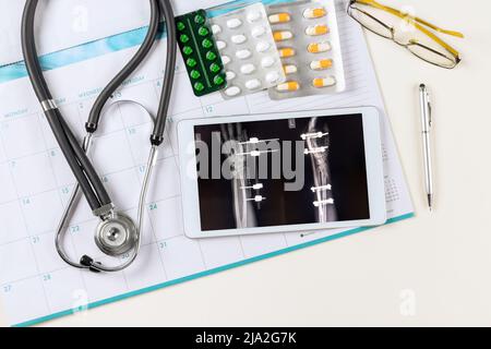 X-ray image on doctors using digital tablet of doctor desk table with stethoscope Stock Photo