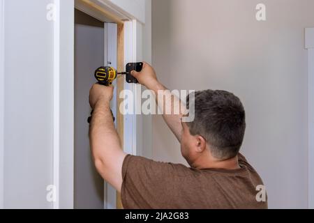 Door hinges on the white door frame with screws Stock Photo