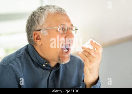 Close-up Of A Man Using Asthma Inhaler Stock Photo