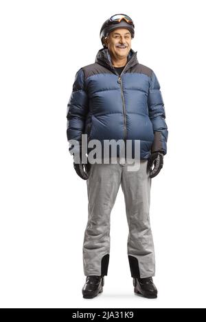 Full length portrait of a mature man in a winter jacket skiing boots and helmet smiling at camera isolated on white background Stock Photo