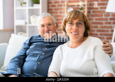 Happy Couple Family Wearing Eye Glasses On Couch Stock Photo