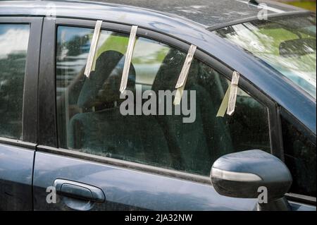 a damaged car side window temporarily fixed with a tape, outdoor shot Stock Photo
