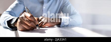 Close-up Of A Businessman's Hand Filling Contract Form Stock Photo