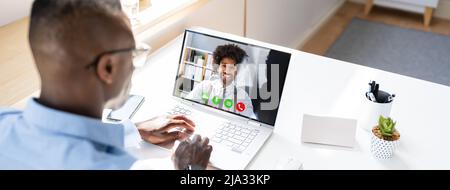Close-up Of A Businessperson's Videoconferencing With Male Colleague On Laptop Stock Photo