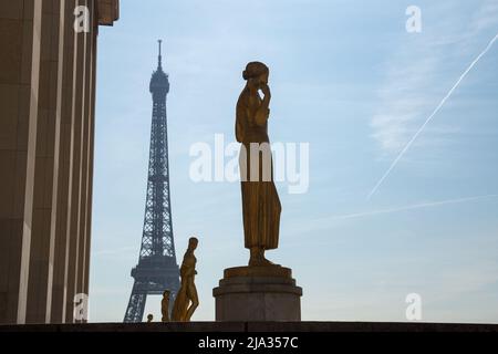 Paris, France, March 27 2017: Golden bronze statues in the Trocadero garden, Eiffel tower in the background. Stock Photo