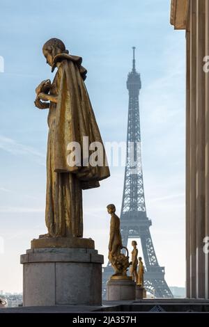 Paris, France, March 27 2017: Golden bronze statues in the Trocadero garden, Eiffel tower in the background. Stock Photo