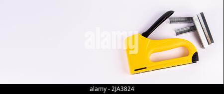 Staple gun and staples on a white background. Copy space. Stock Photo
