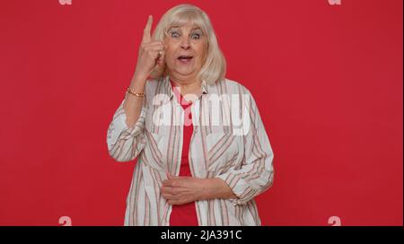 Inspired senior woman pointing finger up, showing Eureka gesture solution, idea, inspiration, answer Stock Photo