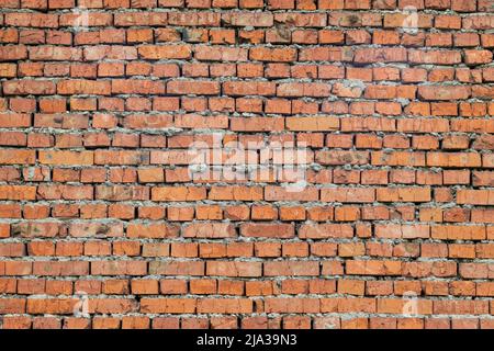 Red brick wall with cement. Rough surface texture. Texture of an old brick wall. Stock Photo