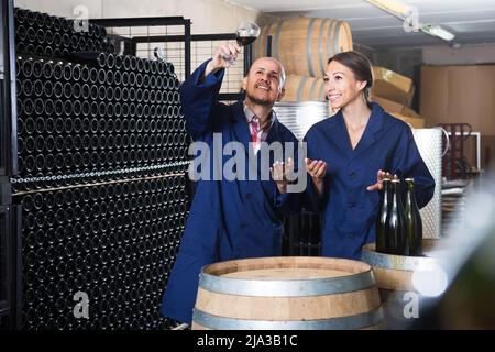 Two concentrated winery workers in aging section of factory Stock Photo