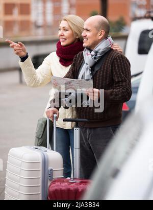 Spouses with baggage and map Stock Photo