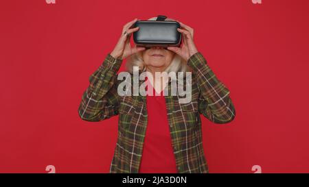Woman using virtual reality futuristic technology VR headset helmet to play simulation 3D video game Stock Photo