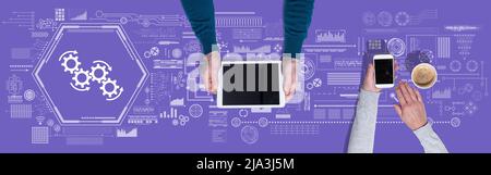 Top view of hands using digital tablet and mobile phone with symbol of workflow concept Stock Photo