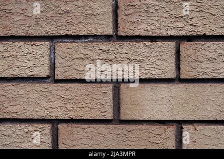 Image of rough briicks on the wall in a city centre. The texture shows bricks that are weathered and worn. Stock Photo