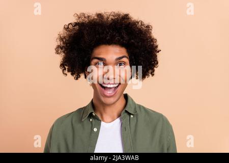 Portrait of attractive crazy cheerful wavy-haired guy laughing having fun isolated over beige pastel color background Stock Photo
