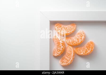 Five clementine tangerine segment on white top view with copy space for text. 5 mandarine pieces Stock Photo