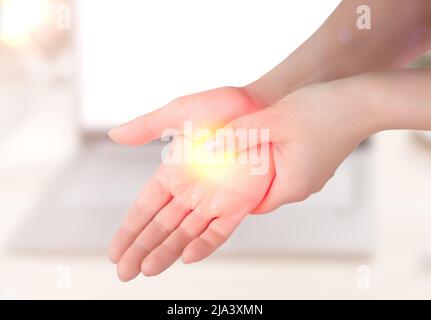 Woman holding her wrist pain from using computer. Office syndrome hand pain by occupational disease. Carpal tunnel syndrome, arthritis, neurological d Stock Photo