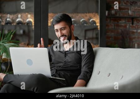 satisfied wine shop owner looking at his laptop screen . Stock Photo